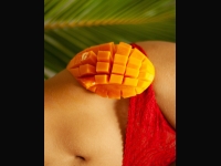 Cut mango half balanced on the hip of a person in red lace underwear